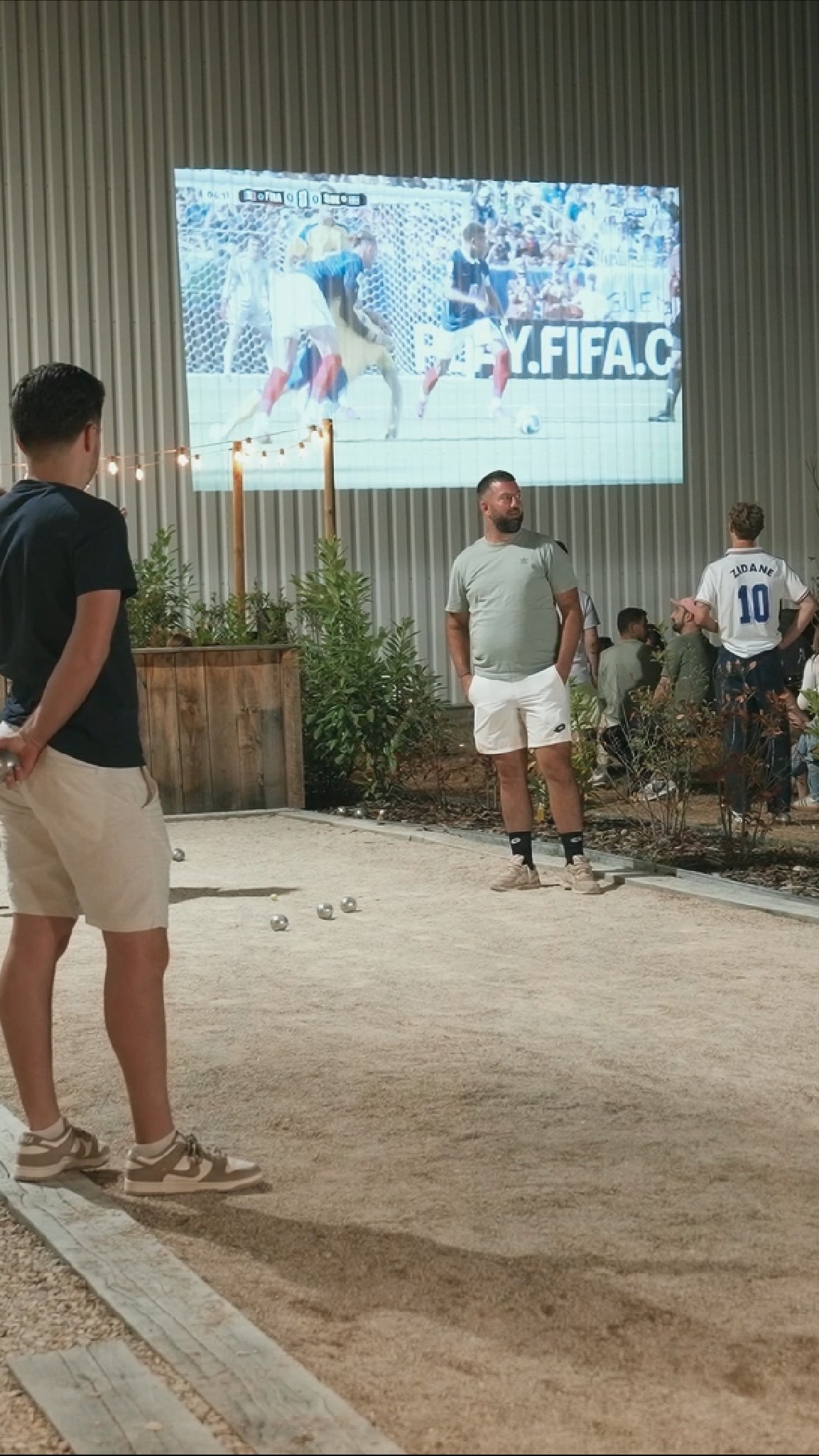Retransmission d'un match de la Coupe du monde 2026 sur écran géant installé par Reveo au Make It Padel Olivet, devant le terrain de pétanque du club