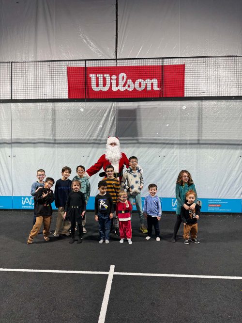 Photo de groupe des enfants avec le Père Noël sur les terrains du Make It Padel Orléans lors de l’événement de fin d’année